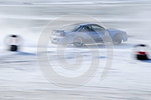 Blue car races along the course during the ice drifting competition